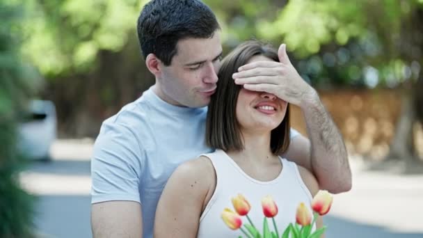 Piękna Para Niespodzianka Bukietem Kwiatów Okrywających Oczy Przytulających Się Parku — Wideo stockowe