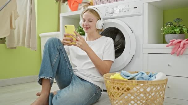 Çamaşır Odasında Müzik Dinleyen Genç Sarışın Kadın — Stok video