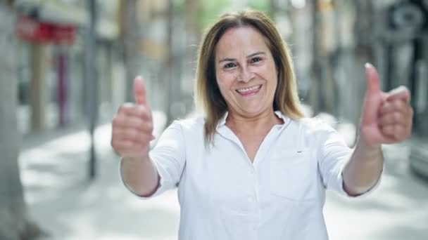 Medelåldern Hispanic Kvinna Ler Säker Gör Tecken Med Tummar Upp — Stockvideo