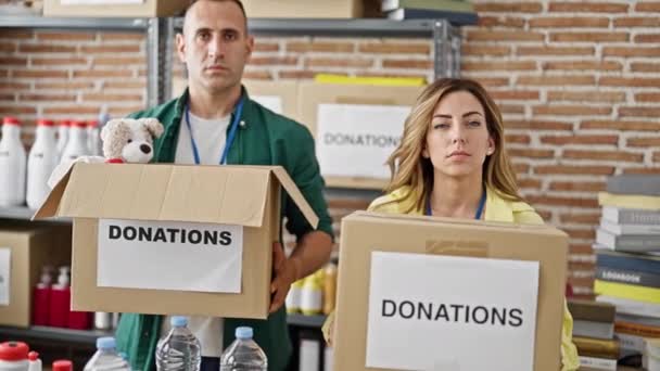 Ehrenamtliche Männer Und Frauen Halten Spendenpakete Mit Ernstem Gesicht Charity — Stockvideo