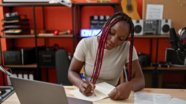 Uśmiechnięta Afrykańska Kobieta Muzyk Mistrzowsko Robi Notatki Laptopie Podczas Ekscytującej — Wideo stockowe