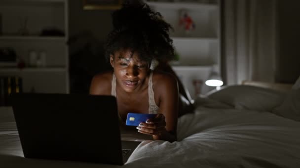 アフリカ系アメリカ人女性 ベッドルームでベッドに横たわるラップトップとクレジットカードで買い物 — ストック動画