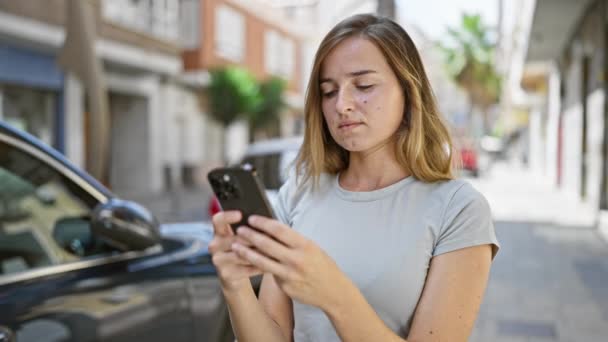 화창한 거리에 디지털 대화에 그녀의 스마트폰을 만지는 즐거운 — 비디오
