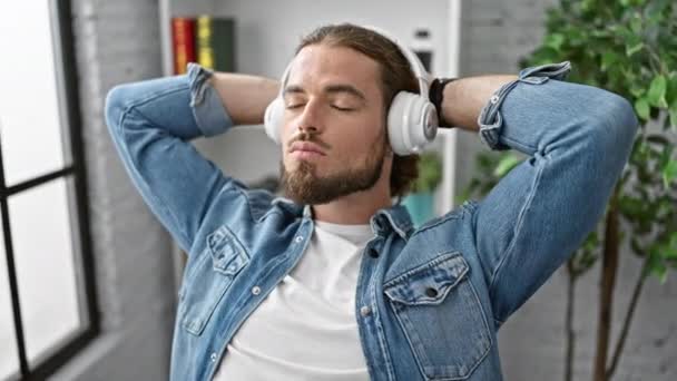Молодой Латиноамериканец Бизнесмен Слушает Музыку Расслабленной Офисе — стоковое видео