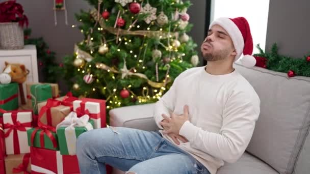 Jovem Hispânico Sofrendo Dor Estômago Usando Chapéu Natal Casa — Vídeo de Stock
