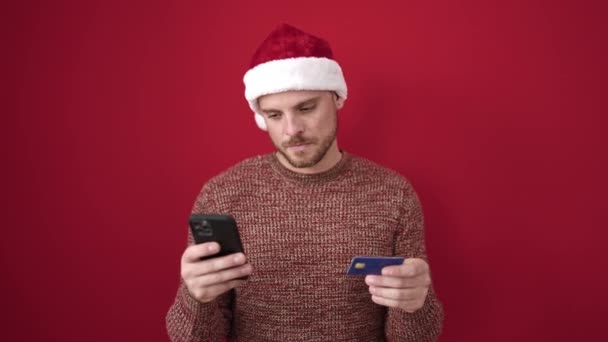 Młody Biały Mężczyzna Pomocą Smartfona Płacąc Karty Kredytowej Izolowane Czerwone — Wideo stockowe