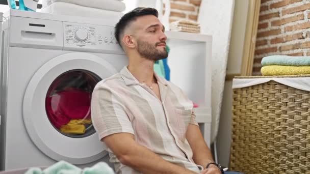 Ung Latinamerikansk Man Lutar Sig Mot Tvättmaskin Stressad Tvättstuga — Stockvideo