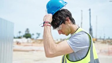 İspanyol asıllı genç bir mimar inşaat alanında ciddi bir yüzle duruyor.