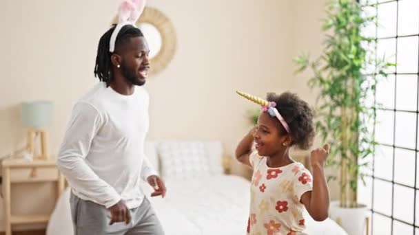 アフリカ系アメリカ人の父親と娘が寝室で面白いダイアカデミーダンスをしている — ストック動画