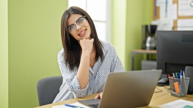 Ofiste çalışan genç beyaz kadın iş adamı dizüstü bilgisayar kullanıyor.