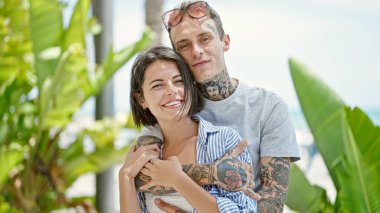 Güzel çift gülümsüyor. Parkta birbirlerine sarılıyorlar.