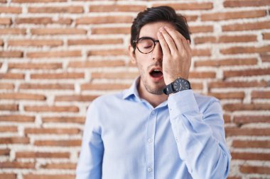 Tuğla duvar arkasında duran İspanyol genç adam esnemekten yoruldu. Yüzün yarısını, gözünü ve ağzını eliyle kapattı. Yüzüm acıyor.. 