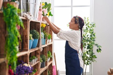 Çiçekçide çiçek taşıyan güzel bir İspanyol kadın.