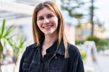 Sokakta kendine güvenen genç sarışın kadın gülümsüyor