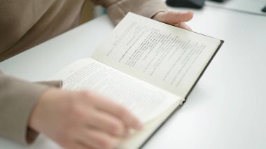 Kütüphane üniversitesinde kitap okuyan güzel İspanyol bir kadın öğrenci.