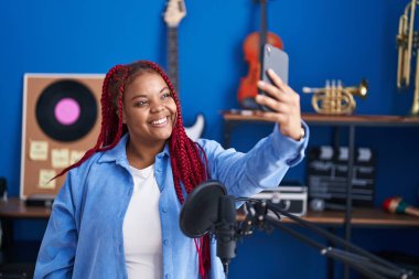 African american woman artist make selfie by smartphone at music studio