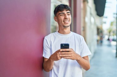 Sokakta akıllı telefon kullanan, kendine güvenen genç bir İspanyol.