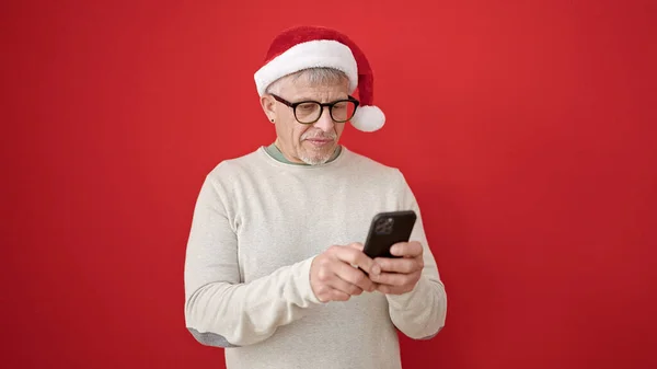 Grauhaariger Mann Mittleren Alters Trägt Weihnachtsmütze Mit Smartphone Über Isoliertem — Stockfoto