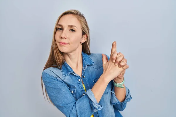 Young Blonde Woman Standing Blue Background Holding Symbolic Gun Hand — Stock Photo, Image