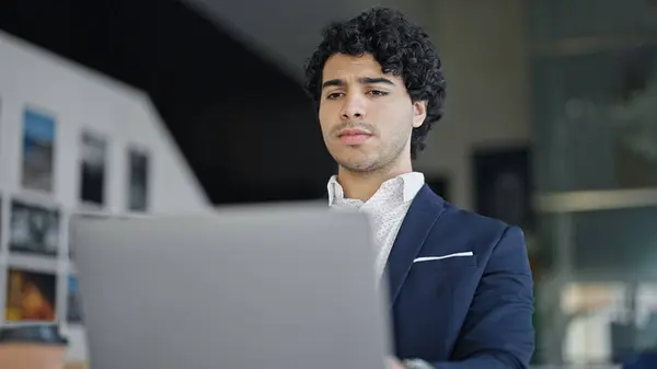 Young latin man business worker using laptop at office
