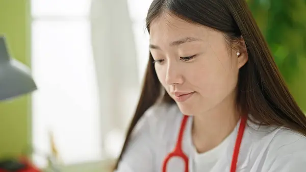 Ung Kinesisk Kvinna Läkare Sitter Bordet Med Avslappnad Uttryck Kliniken — Stockfoto
