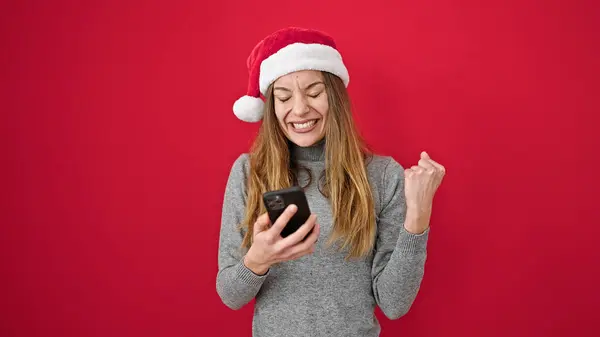 Νεαρή Καυκάσια Γυναίκα Φοράει Χριστουγεννιάτικο Καπέλο Χρησιμοποιώντας Smartphone Πάνω Από — Φωτογραφία Αρχείου