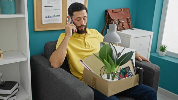 Young Hispanic Man Being Fired Sitting Sofa Talking Smartphone Office — Stock Photo, Image