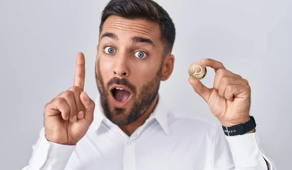 Handsome Hispanic Man Holding Polkadot Cryptocurrency Coin Surprised Idea Question — Stock Photo, Image