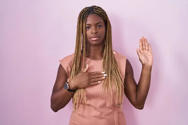Африканская Американка Плетеными Волосами Стоящая Розовом Фоне Ругаясь Рукой Груди — стоковое фото
