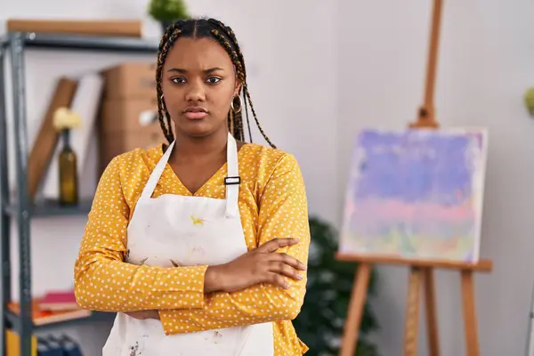 African american woman with braids at art studio skeptic and nervous, disapproving expression on face with crossed arms. negative person.