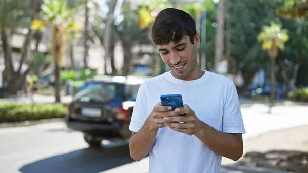 Vrolijke Jonge Spaanse Man Blij Met Behulp Van Mobiele Technologie — Stockfoto