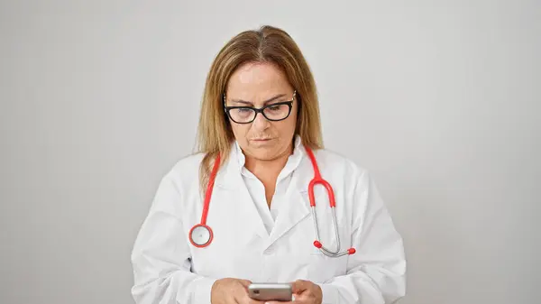 Latynoska Kobieta Średnim Wieku Lekarz Pomocą Smartfona Poważną Twarzą Izolowanym — Zdjęcie stockowe