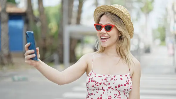 Young blonde woman tourist smiling confident having video call at street