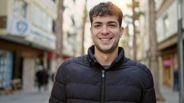 Young hispanic man smiling confident at street