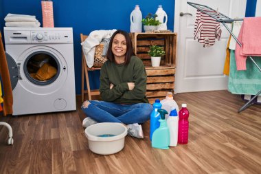 Genç İspanyol kadın çamaşırları elleriyle yıkıyor mutlu yüz, kollarını kavuşturup kameraya bakıyor. pozitif kişi. 