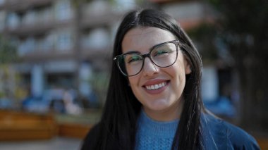 Sokakta kendinden emin gülümseyen genç İspanyol kadın.