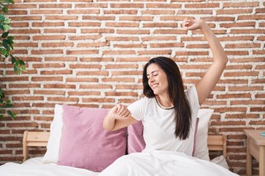 Genç, güzel İspanyol bir kadın yatak odasında kollarını açarak uyanıyor.