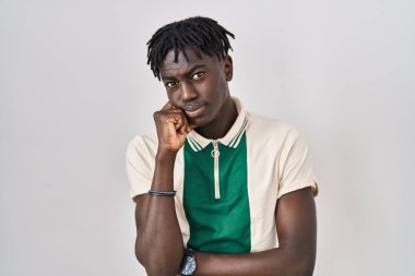 Münzevi arka planda elleri çenesinde dikilip soru sormayı düşünen Afrikalı bir adam, düşünceli bir ifade. Düşünceli bir yüzle gülümsüyor. şüphe kavramı. 