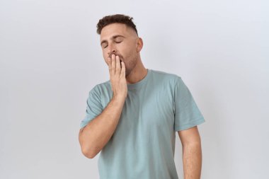 Beyaz arka planda duran İspanyol sakallı adam ağzıyla ağzını kapatmaktan sıkılmış. Huzursuz ve uykulu.. 