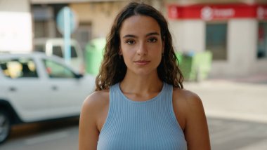 Sokakta ciddi bir ifadeyle duran genç, güzel İspanyol kadın.