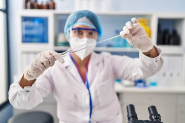 Eczanede antijen testi yapan tıbbi maske takan genç ve güzel İspanyol kadın bilim adamı.