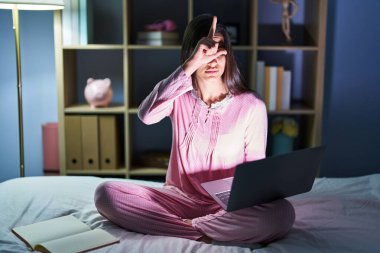 Genç İspanyol kadın bilgisayarı yatakta kullanıyor. Alnında parmakları olan insanlarla dalga geçiyor. Ezik hareketler yapıyor, alay ediyor.. 