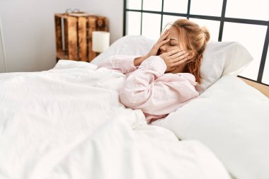 Young caucasian woman stressed lying on bed at bedroom