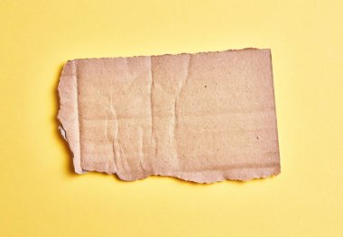  İzole edilmiş sarı arkaplanda bir karton parçası var.