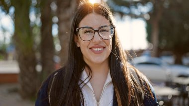 Sırt çantalı genç İspanyol kadın turist sokakta gülümsüyor.