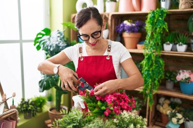 Çiçekçide çiçek kesen güzel İspanyol kadın.