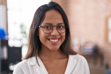 Genç İspanyol iş kadını ofiste kendine güvenen bir gülümseme