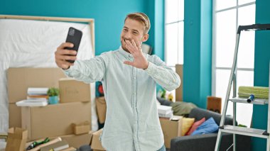 Kafkasyalı genç bir adam yeni evinde gülümsüyor.