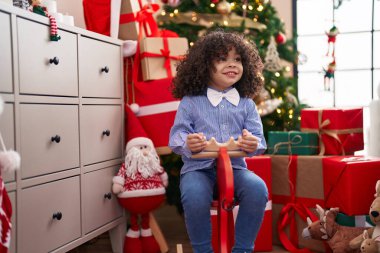 Afrika kökenli Amerikalı çocuk evde Ren geyiğiyle oynuyor Noel ağacında sallanıyor
