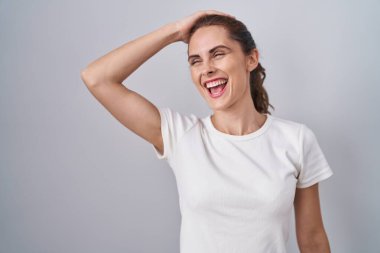 Güzel esmer kadın izole edilmiş arka planda duruyor. Gülümsüyor, saçlarına dokunuyor, el hareketi yapıyor, çekici ve şık poz veriyor. 